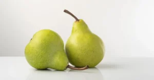 A few pears on a white counter with a soft gray background, perfect for cooking.