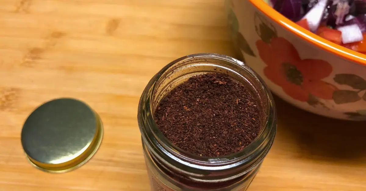 Jar of ground sumac spice used in Israeli salad recipe.