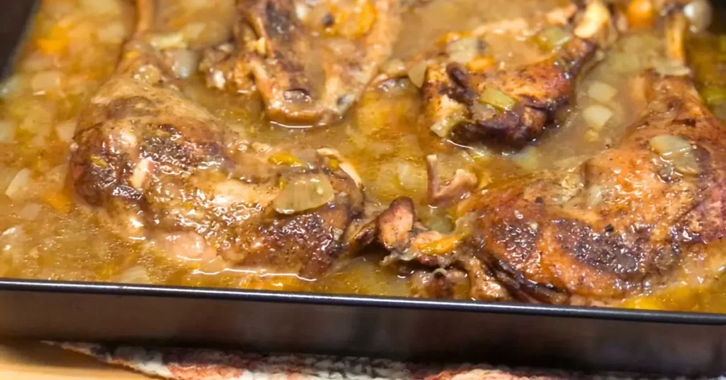 Baked turkey wings and leg quarters in a pan with homemade pan gravy, carrots, onions, and bell peppers
