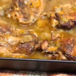 Baked turkey wings and leg quarters in a pan with homemade pan gravy, carrots, onions, and bell peppers