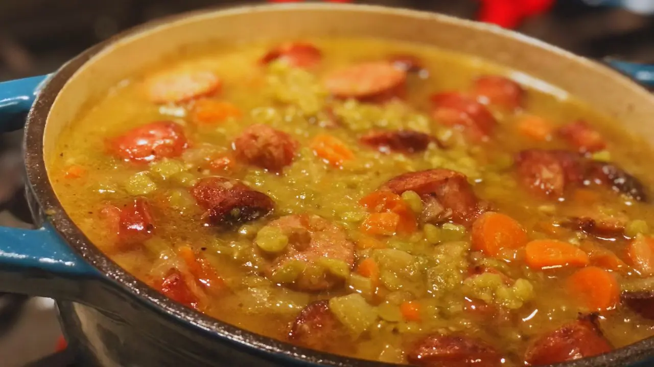 close up of pot of chunky split pea soup with smoked sausage on a stove
