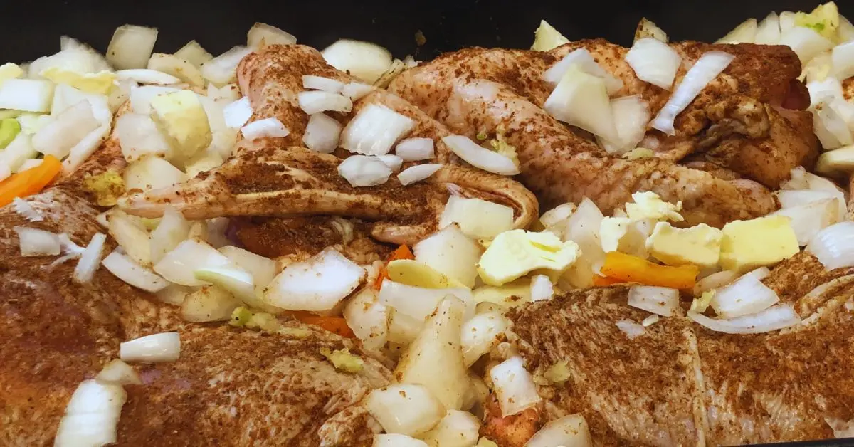 turkey legs and wings in roaster with onions, peppers and celery