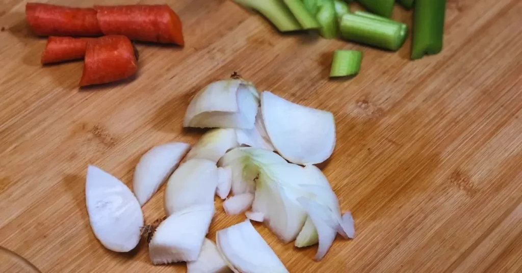 broth veggies on a cutting board, onions, carrots, and celery rough chopped