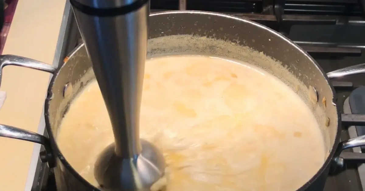 Immersion blender blending simple creamy potato soup to desired texture