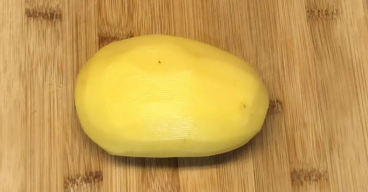 Yellow potato on a cutting board ready to be diced for simple creamy potato soup