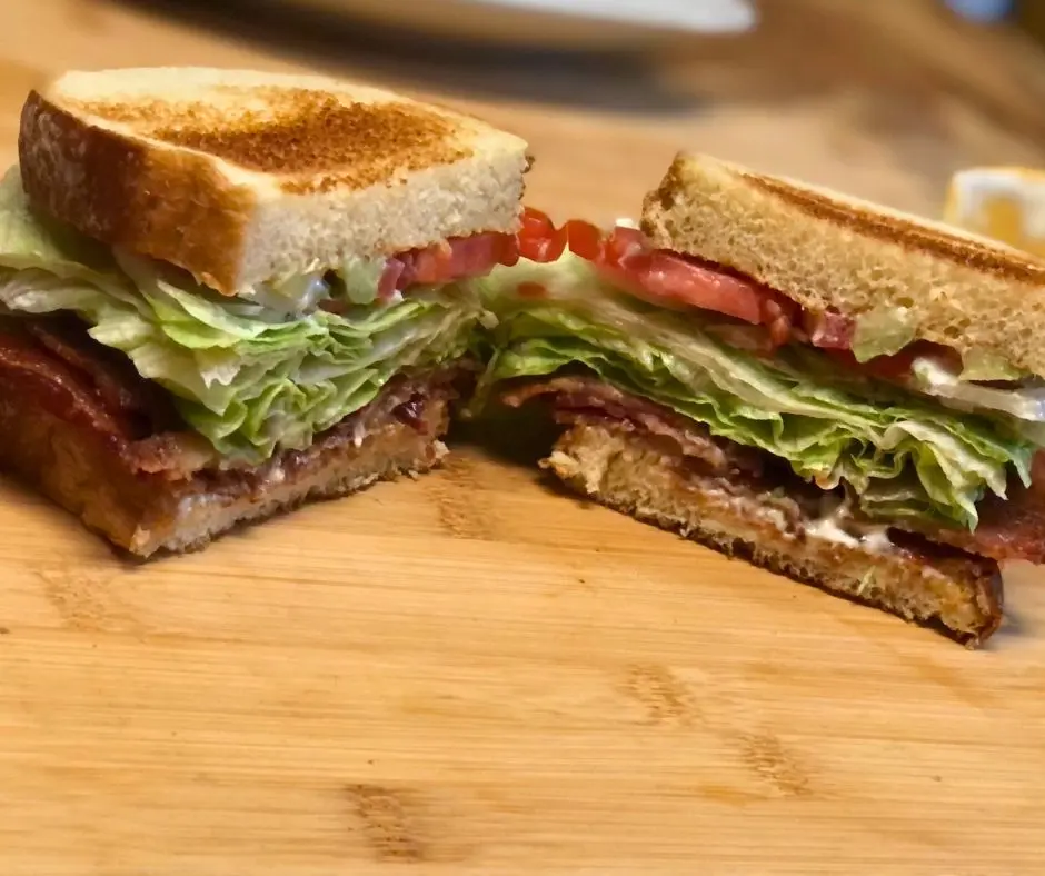 Homemade Bacon BLT sandwich cut in half showing layers of bacon, lettuce, and tomato