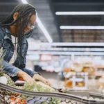 Woman grocery shopping with a full cart while meal planning on a budget