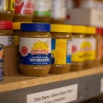 Pantry shelf neatly organized with labeled jars, canned goods, and dry ingredients for home cooking
