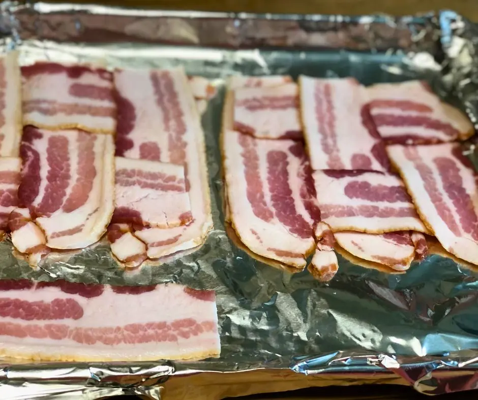 Raw bacon woven together on foil lined baking sheet