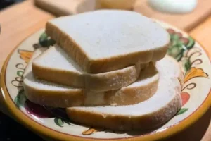 Stack of white bread slices used to make Southern tomato pudding.