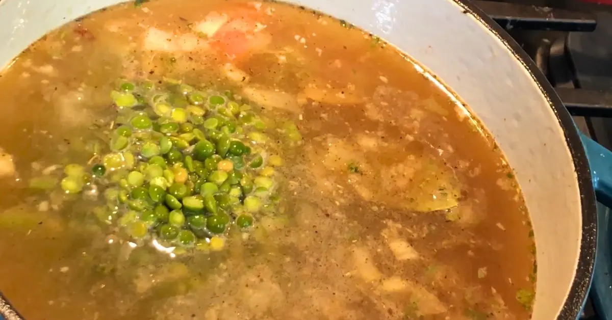 Green split peas added to seasoned broth in a Dutch oven