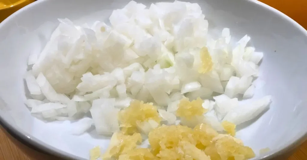 Chopped onion and fresh garlic prepared for meatless collard greens