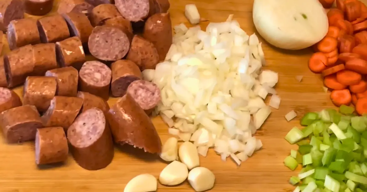 Diced smoked sausage, onion, carrots, and celery prepared for smoky split pea soup